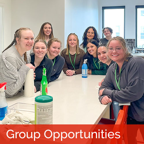 Group of female volunteers around a table in the kitchen after cleaning