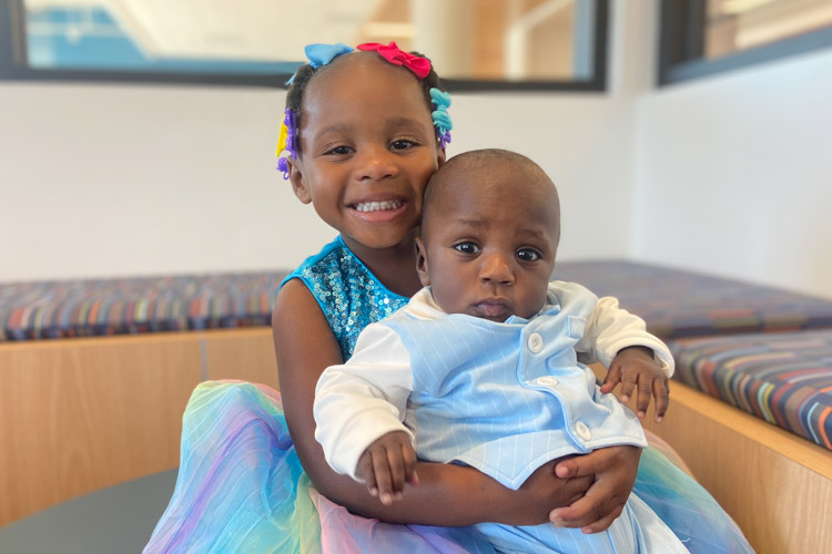 A little girl hugging her little brother