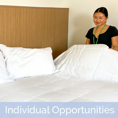 Young woman volunteer making bed in guest room at RMHC Dayton