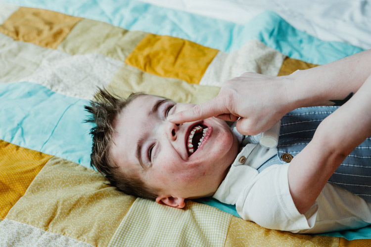 Young son laughing on bed